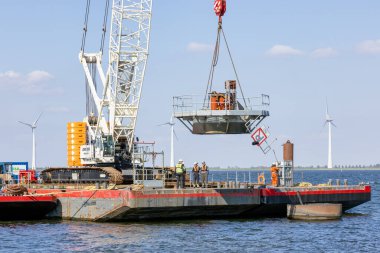Lelystad, Hollanda - 22 Nisan 2022: Turna gemisi eski denizaşırı rüzgar türbininin yıkımıyla temel alınıyor