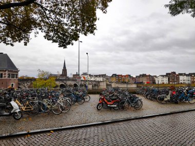 Maastricht, Hollanda 'daki Maas gezinti alanında Kafe t Pothuiske' nin önünde Het Bat 'a park edilmiş bir sürü bisiklet var.