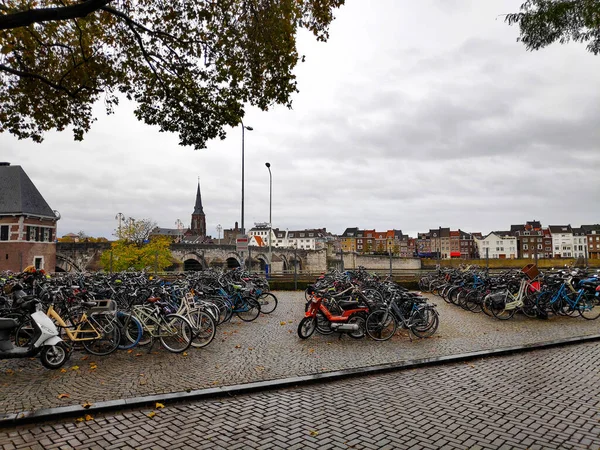Maastricht, Hollanda 'daki Maas gezinti alanında Kafe t Pothuiske' nin önünde Het Bat 'a park edilmiş bir sürü bisiklet var.