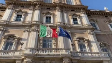 İtalyan ve Avrupa bayrakları hükümet sarayının ön cephesinde sallanıyor.