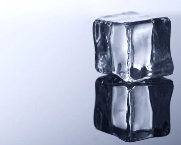 Ice cube on blue background. — Stock Photo, Image