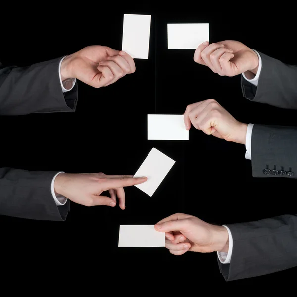 Hands hold business cards collage on black — Stock Photo, Image