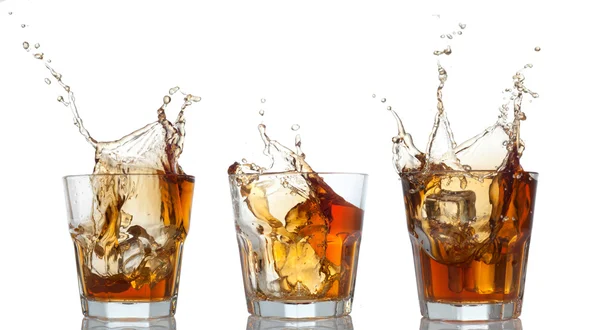 Whisky conjunto salpicar fuera del cristal en blanco — Foto de Stock