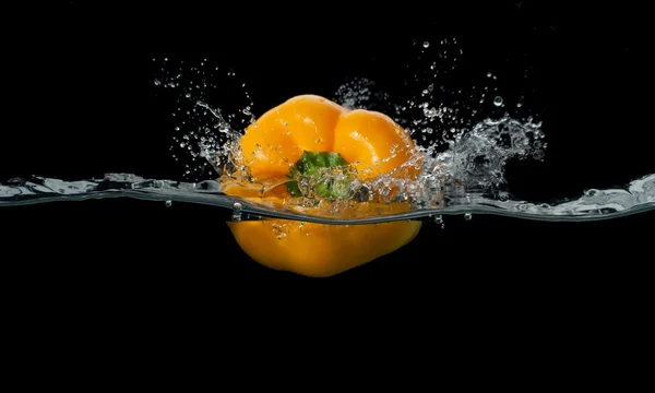 Fresh pepper splash in water on black background — Stock Photo, Image