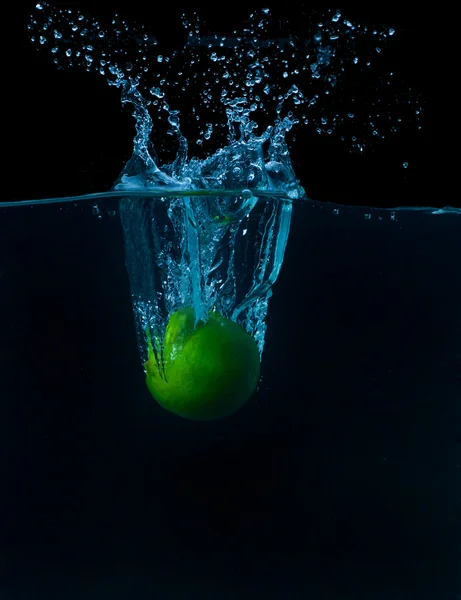 The lime slices falling into the water . — Stok Foto