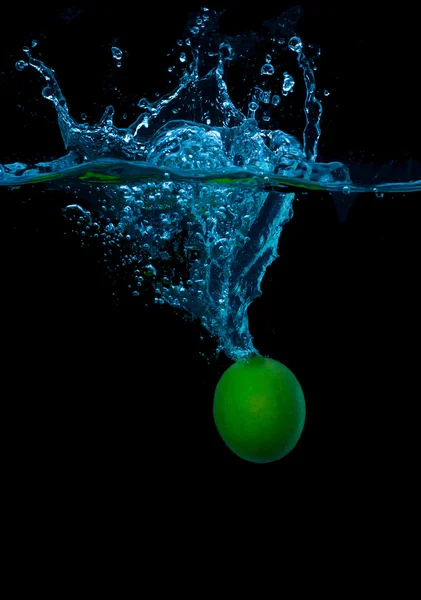 Lime skivor faller i vattnet . — Stockfoto