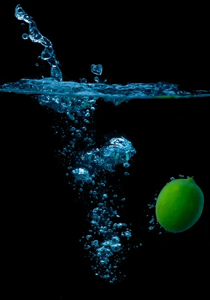 The lime slices falling into the water . — Stock Photo, Image