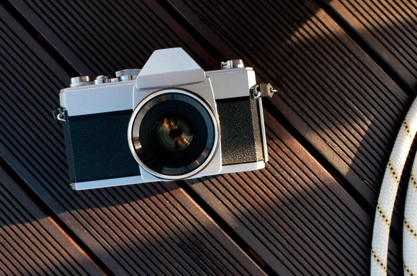 Old retro camera on vintage wooden boards abstract background — Stock Photo, Image