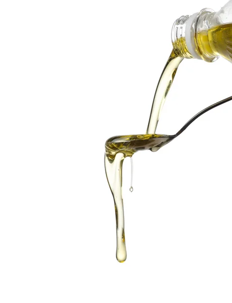 Pouring oil on spoon isolated — Stock Photo, Image