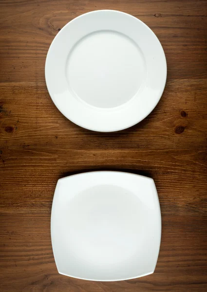 Empty white plate on wooden table — Stock Photo, Image