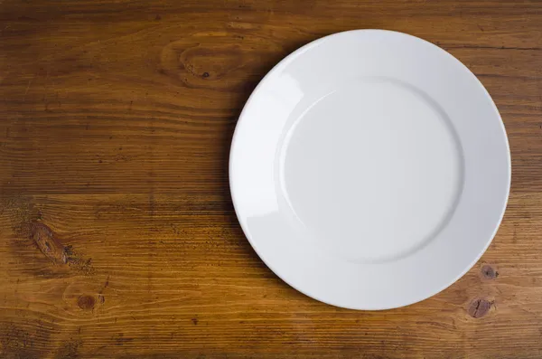 나무 탁자 위에 놓여 있는 빈흰 접시 — 스톡 사진