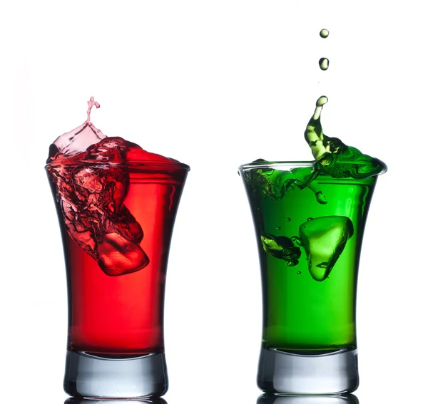 Red cocktail splashing into glass on white — Stock Photo, Image