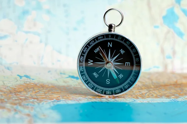 Compass on the map on the area of confusion — Fotografia de Stock