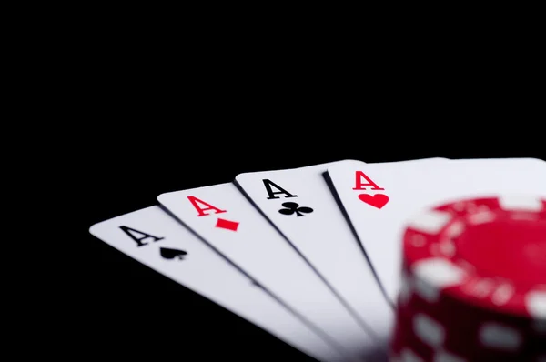 Four aces high on black table with chips – stockfoto