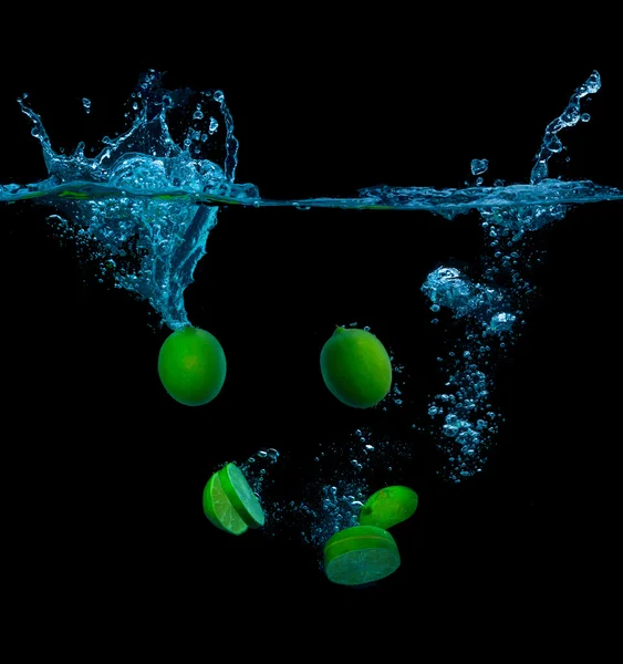 Lime and water splash on a black background — Stock Photo, Image