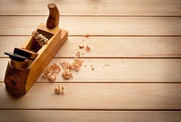 Avión de carpintero sobre fondo de madera — Foto de Stock