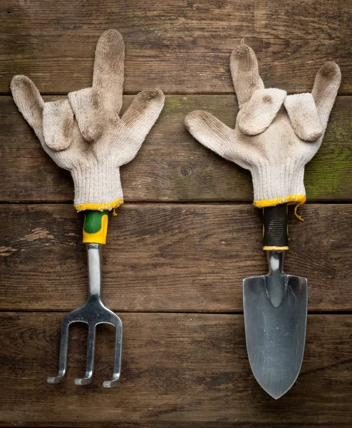 Gardening tools in working gloves on wooden — Stock Photo, Image