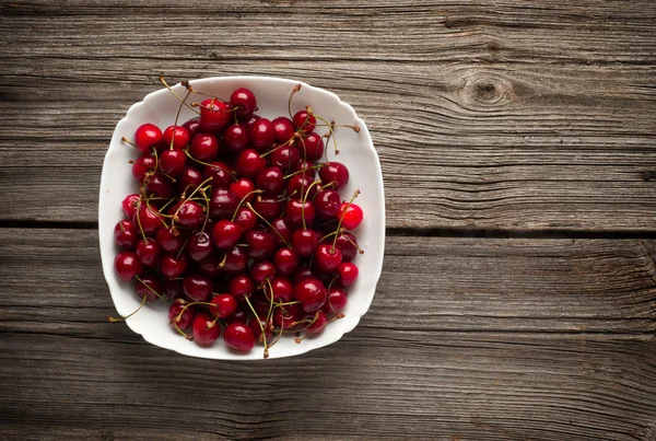 Cuenco de cerezas maduras sobre un fondo de madera —  Fotos de Stock