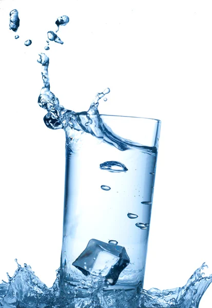 Isbitar som stänker sig i glas vatten — Stockfoto