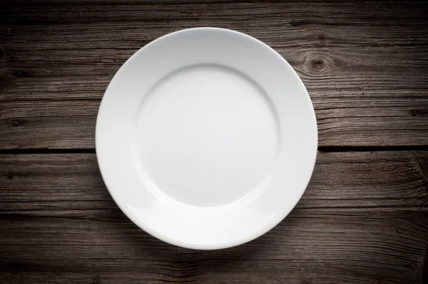 Piatto bianco vuoto su tavolo di legno — Foto Stock