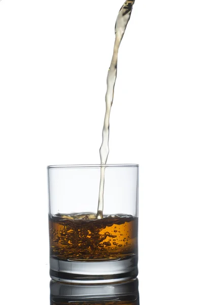 Scotch whiskey splashing out of glass. Isolated on white  backgr — Stock Photo, Image