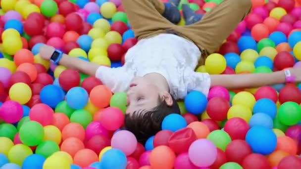Автомобільна дитина в басейні з кольоровими кульками. аутизм спектр розлад — стокове відео