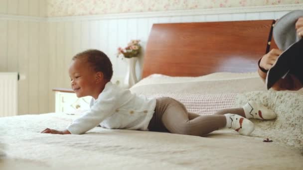 The child is capricious, does not want to dress for a walk. Mother playing with baby — Stock Video