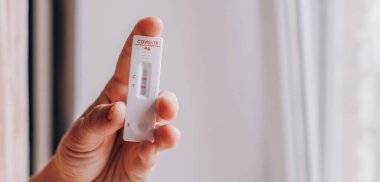 Kadın, COVID 19 testi sırasında Antikor Test kiti tutuyor ve sonuç pozitif. Coronavirus Öz-Burun ya da Ev Testi, Kilitleme ve İzolasyon Konsepti