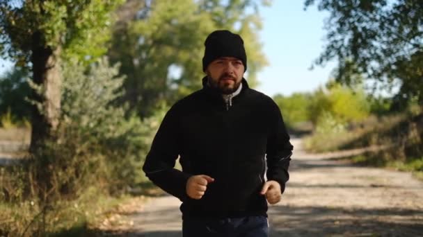 Un uomo che fa jogging, che si allena nel parco. Stile di vita sano, sport all'aria aperta. Rallentatore — Video Stock