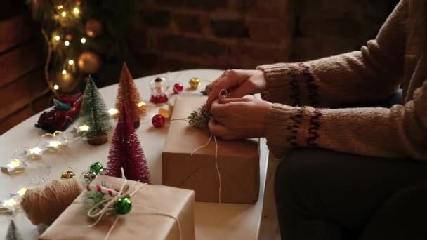 Womans hands wrapping Christmas gift boxes, close up. Unprepared gifts with decor elements and items Christmas or New Year packaging concept. — Vídeo de Stock