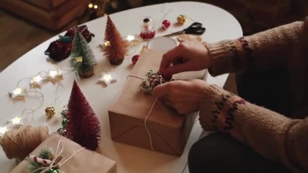 Γυναικεία χέρια τυλίγουν Χριστουγεννιάτικα κουτιά δώρου, κοντά. Ακατέργαστα δώρα με διακοσμητικά στοιχεία και είδη Χριστουγεννιάτικη ή Πρωτοχρονιά έννοια συσκευασίας. — Αρχείο Βίντεο