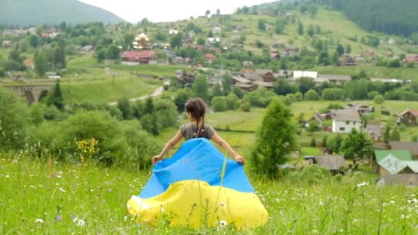 El concepto de un niño con la bandera de Ucrania en el fondo de las montañas. Ucrania independiente. — Vídeos de Stock