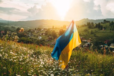 A man with the flag of Ukraine on the background of mountains. Independent of Ukraine. clipart