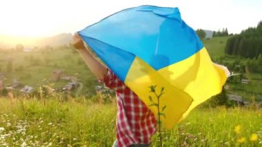 Dağların arkasında Ukrayna bayrağı taşıyan bir adam. Ukrayna 'dan bağımsız.