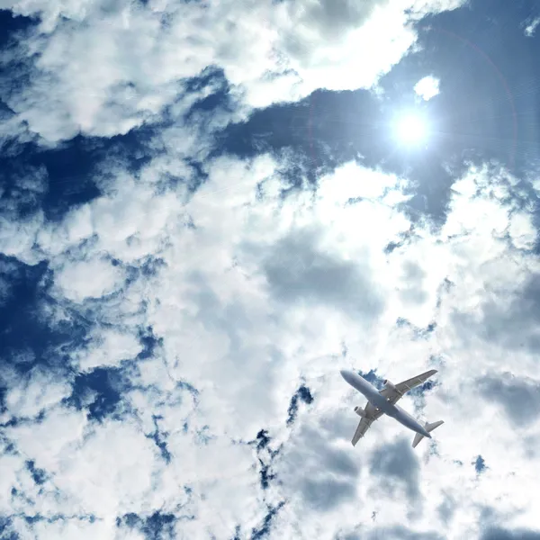 Самолет, летящий над голубыми облаками — стоковое фото