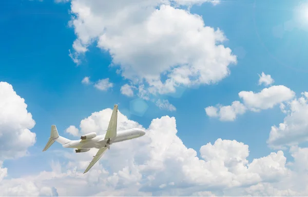 Um avião voando acima de nuvens azuis — Fotografia de Stock