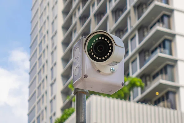 Security surveillance cameras in front of high-rise condominium. CCTV camera home security system