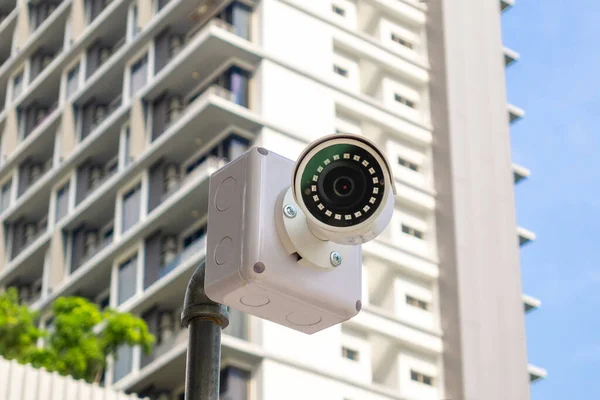 Security surveillance camera in front of high-rise condominium. CCTV camera home security system