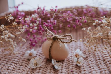 composition of Easter decorations, egg with bow and dried flowers