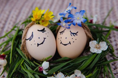 egg with a bow on a textile pink background with white dried flowers and white blooms