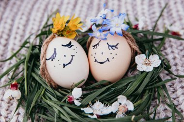 egg with a bow on a textile pink background with white dried flowers and white blooms
