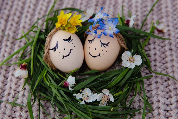 egg with a bow on a textile pink background with white dried flowers and white blooms