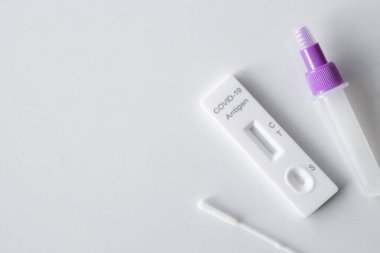 Koronavirüs enfeksiyonu önleme konsepti. Beyaz arka planda antijen ATK test kiti. Üst Manzara. düz yat