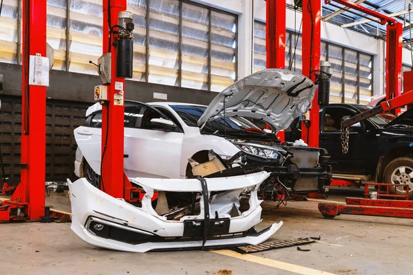 Otomobil tamirhanesinde hafif odaklı ve arka planında ışık olan bir araba.