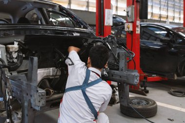 mechanic assembling an engine block of a car in the garage room service with soft-focus and over light in the background. car repair