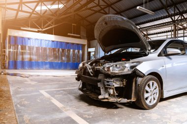 Otomobil tamirhanesinde hafif odaklı ve arka planında ışık olan bir araba.