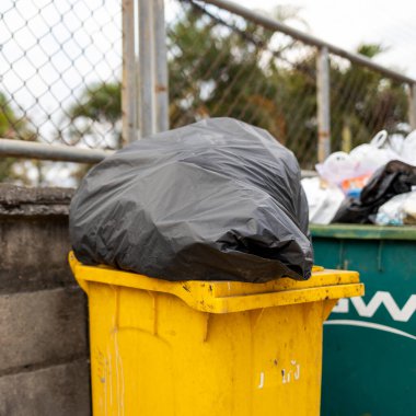 arka planda yumuşak odak ve aşırı ışık ile closeup sarı çöp kutusu