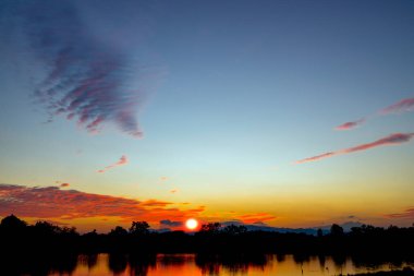 Nehir manzarasında güzel bir siluet gün batımı. Romantik gün batımı dramatik gün batımı 