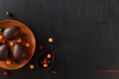 Eski siyah ahşap arka planda lezzetli paskalya yumurtaları. Düz yat. Üst Manzara. Mutlu Paskalyalar konsepti. 3B illüstrasyon