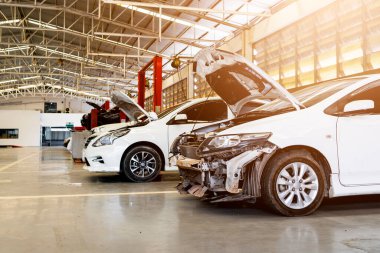 Garaj servis istasyonunda araba tamiri. Arka planda hafif odaklı ve ışığın üstünde.